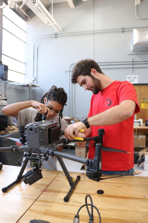 Alex Brown and a teammate assembling a drone in a lab